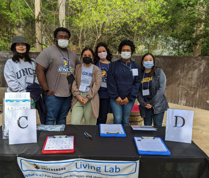 group of students standing at a table promoting the Living Lab