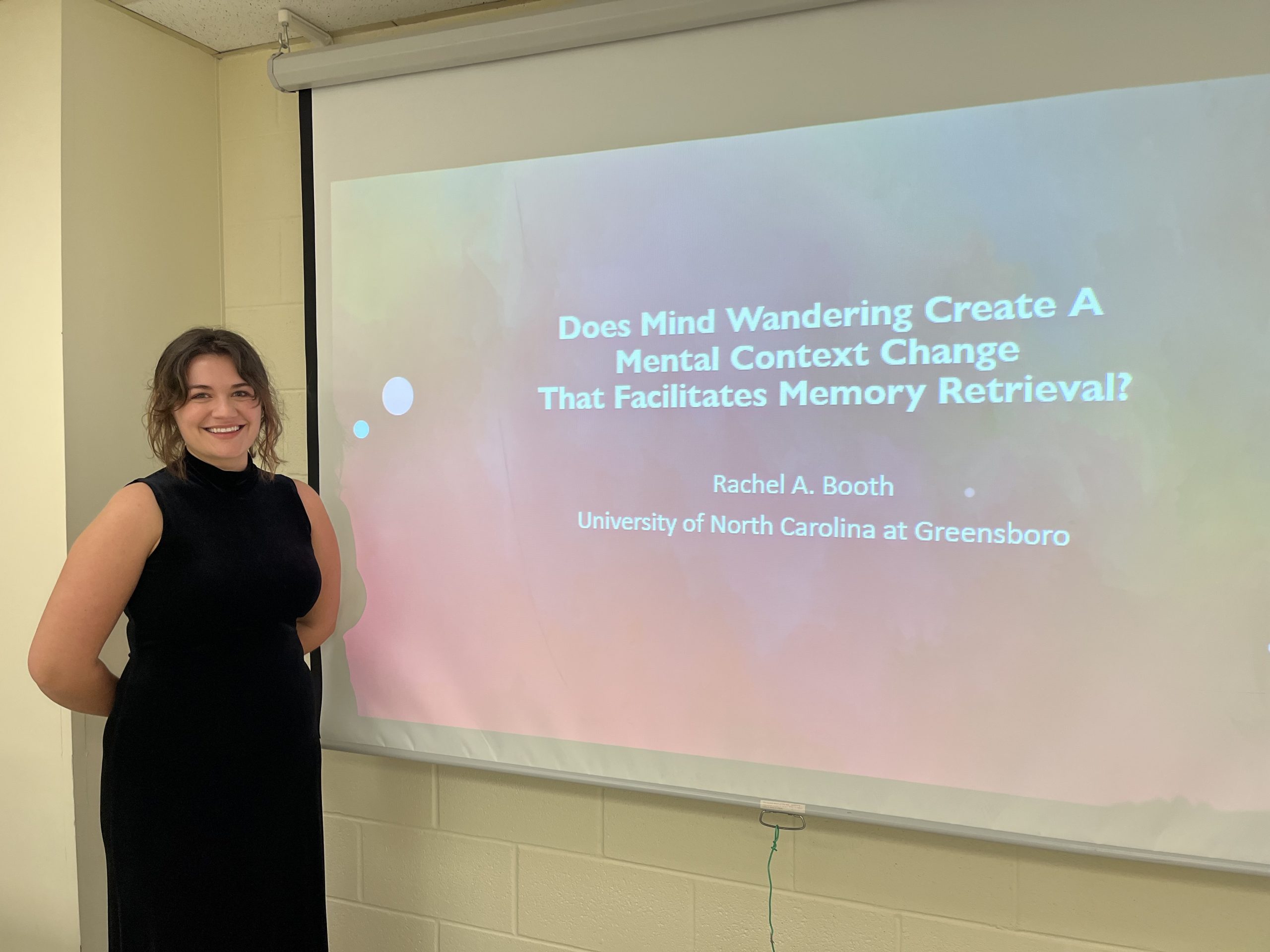 Picture of Rachel Booth next to her thesis title slide.