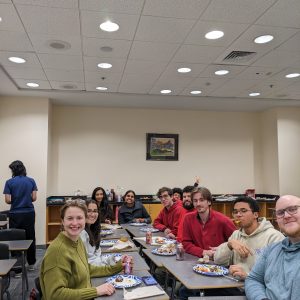 Psychology graduate students seated around a table sharing a meal for Friendsgiving