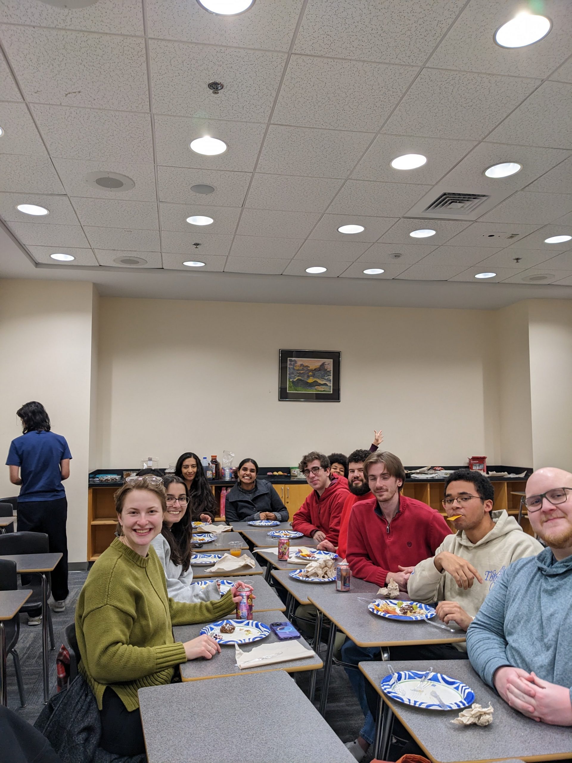 Psychology graduate students seated around a table sharing a meal for Friendsgiving