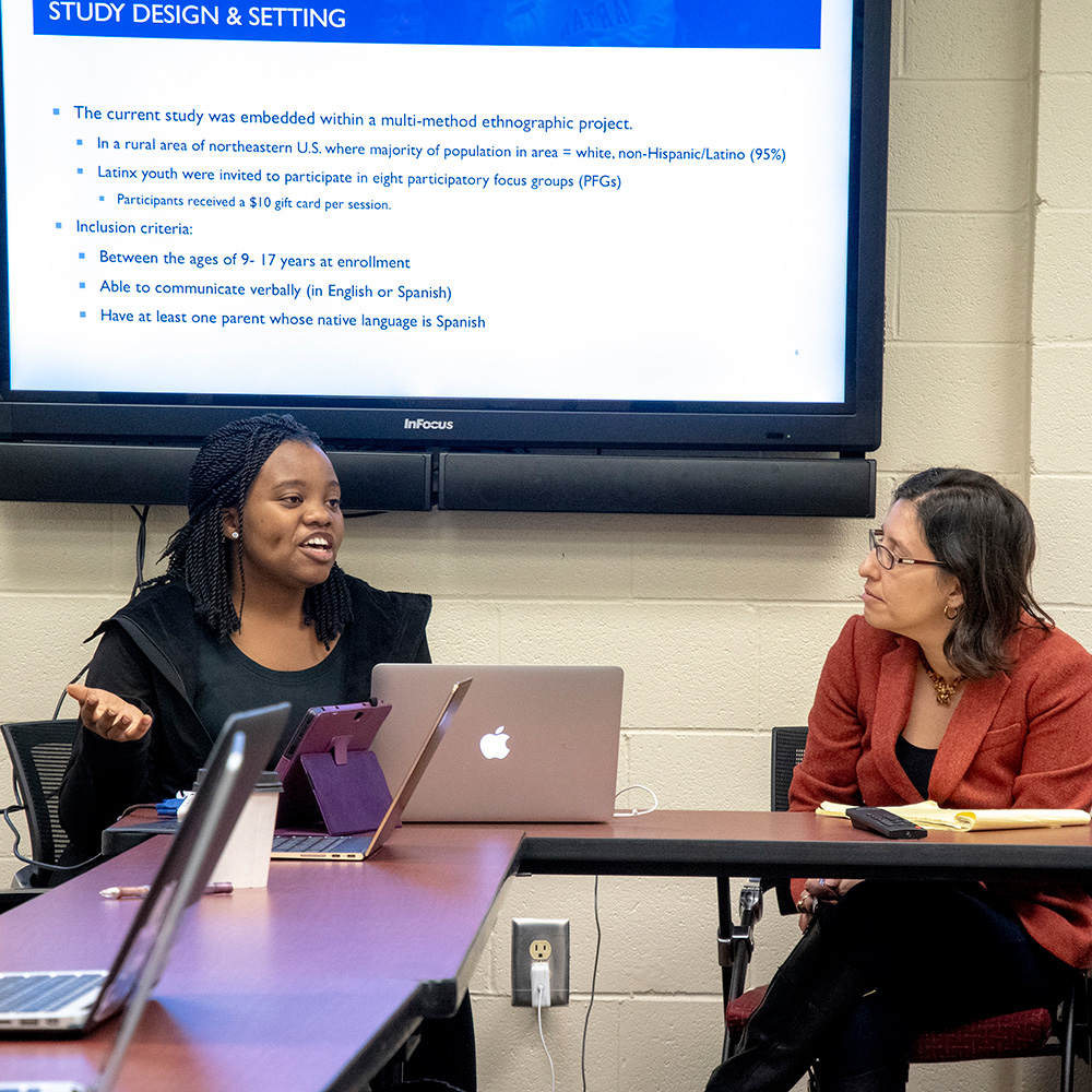 Psychology student and professor engaging in a classroom