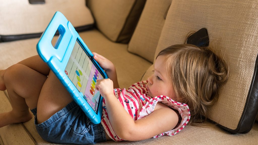 A toddler plays with a tablet computer