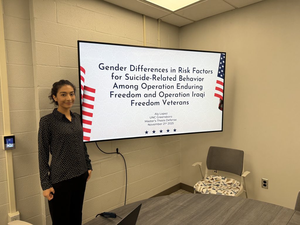 Aly Lopez next to her thesis presentation